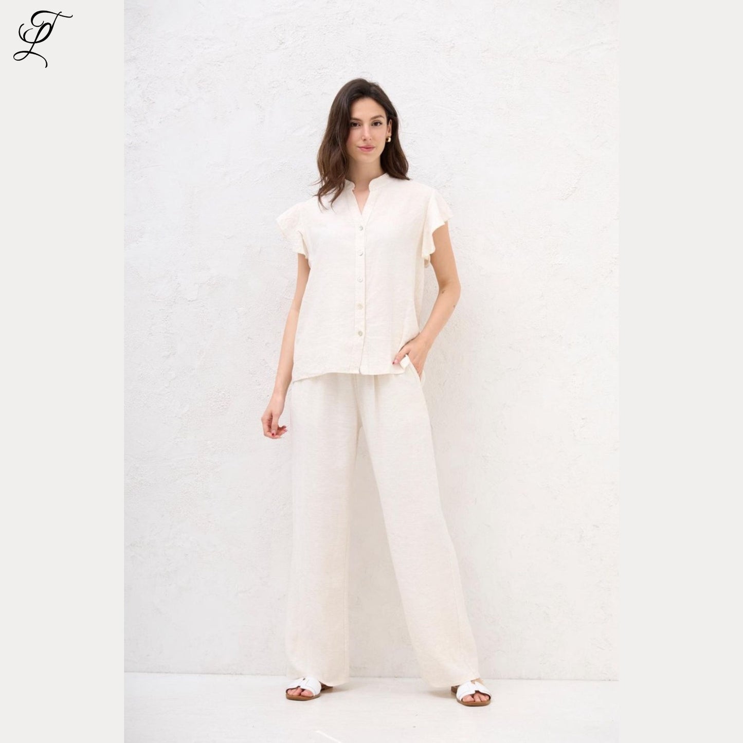 Vrouw draagt Chastar Linnen Blouse in off white met casual ruffle-mouwtjes, perfect voor een luchtige zomerse look.