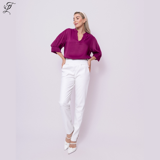 Stijlvolle witte Chastar PU broek met stretch, gedragen met een paarse blouse met pofmouwen en witte pumps. Perfect voor een moderne look tegen een lichte achtergrond. Chastar PU Broek Met Stretch Wit - Home page, Broeken