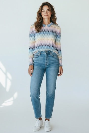 vrouwelijk model draagt zachte top met stretch in zachte kleuren en jeans in lichte achtergrondstudio