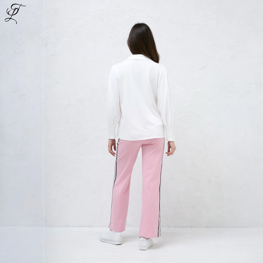 Chastar Stretch Blouse in wit, gedragen met roze broek met zijstreep. Achteraanzicht toont elegante pasvorm met lange mouwen tegen witte muur. Casual styling met witte sneakers. Perfect voor dagelijks comfort en stijl. Blouses, Collectie, Bestsellers.