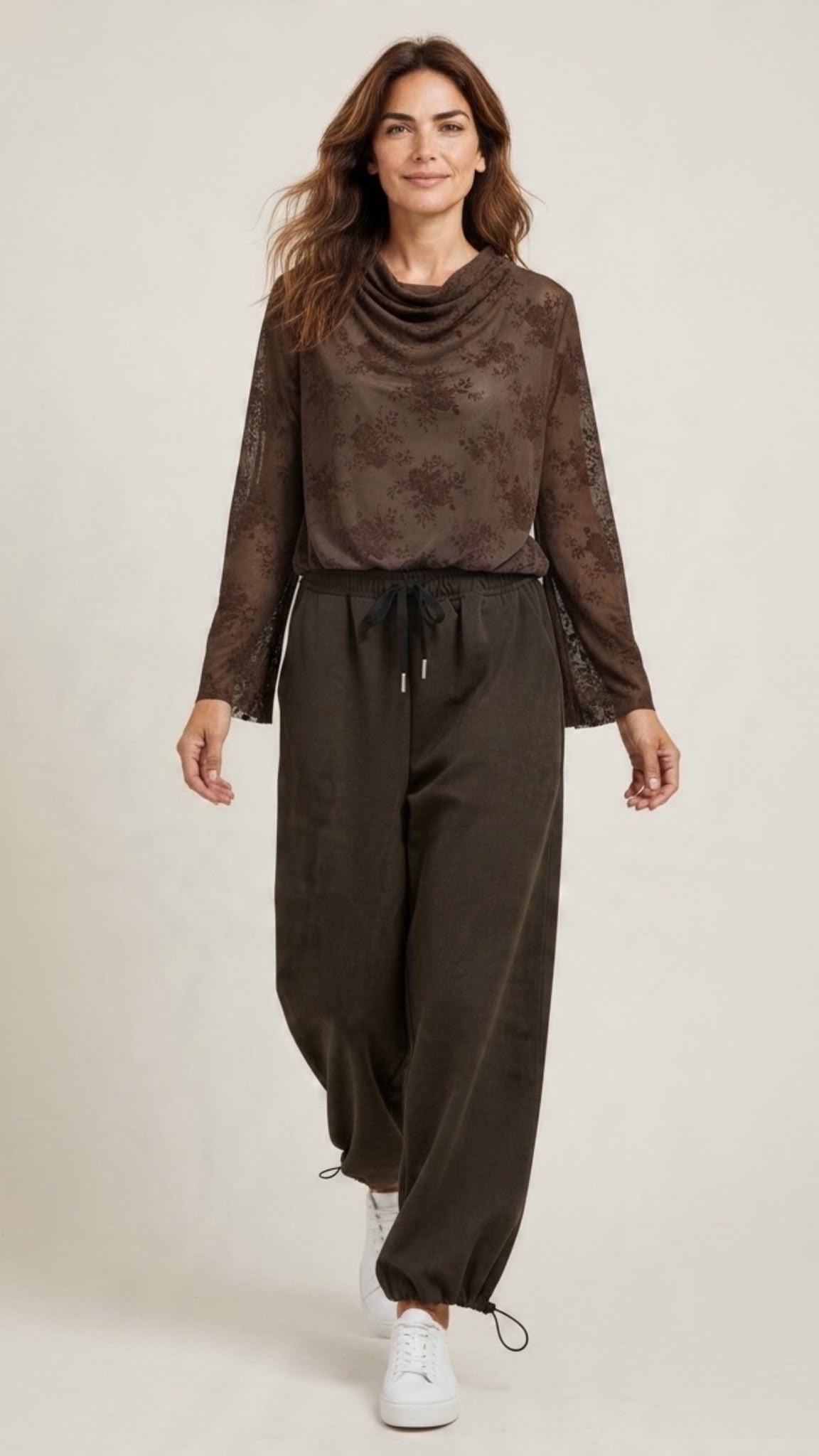 Chastar top Séverine in Choco Bruin met bloemendessin, watervalhals en lange mouwen, gedragen op model.