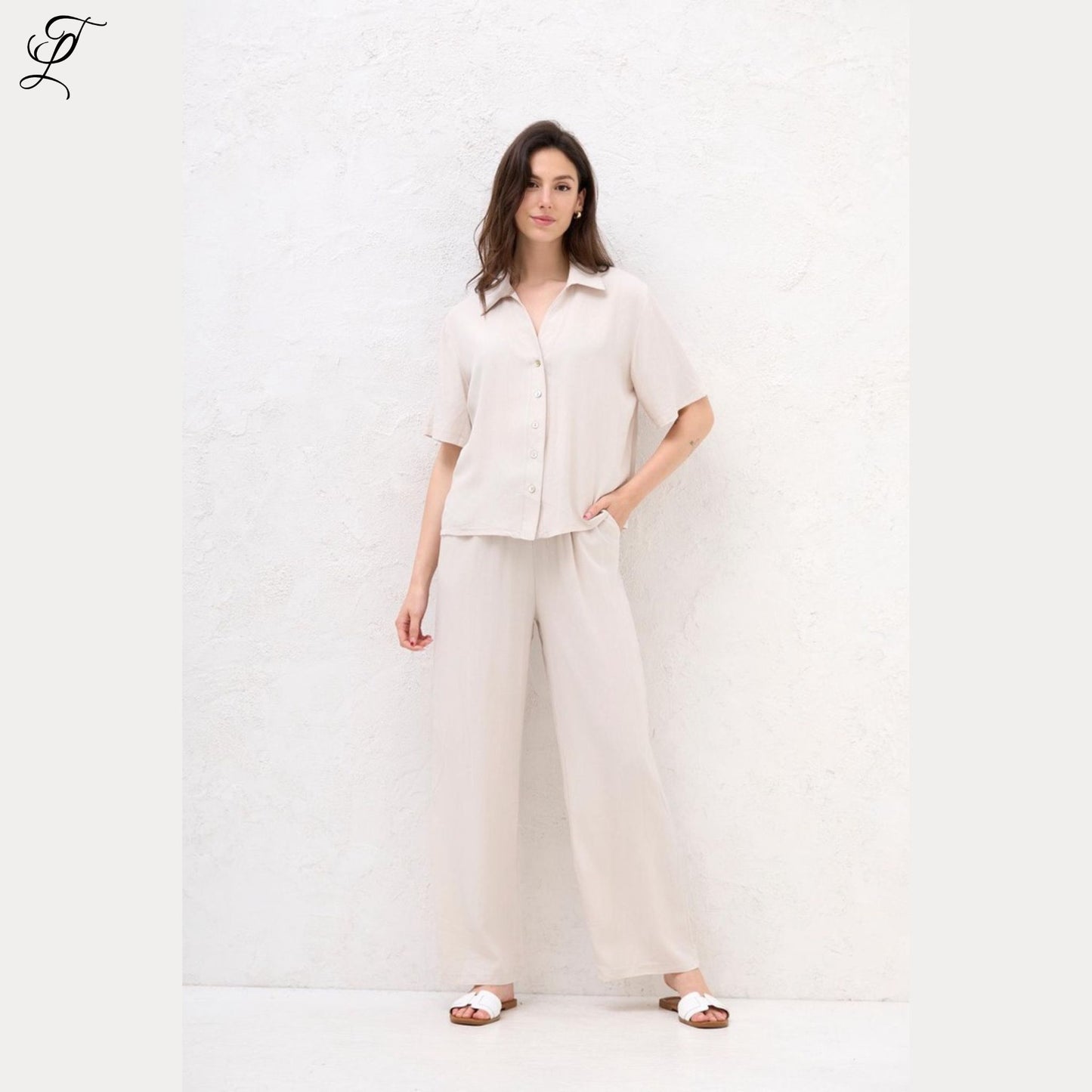 Vrouw draagt lichte, luchtige Chastar Korte Mouwen Blouse met parelmoerknopen voor een relaxte, stijlvolle look.