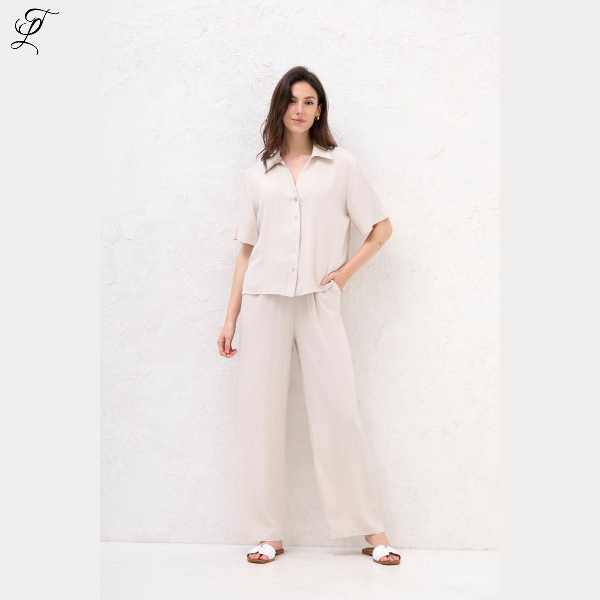 Vrouw draagt lichte, luchtige Chastar Korte Mouwen Blouse met parelmoerknopen voor een relaxte, stijlvolle look.