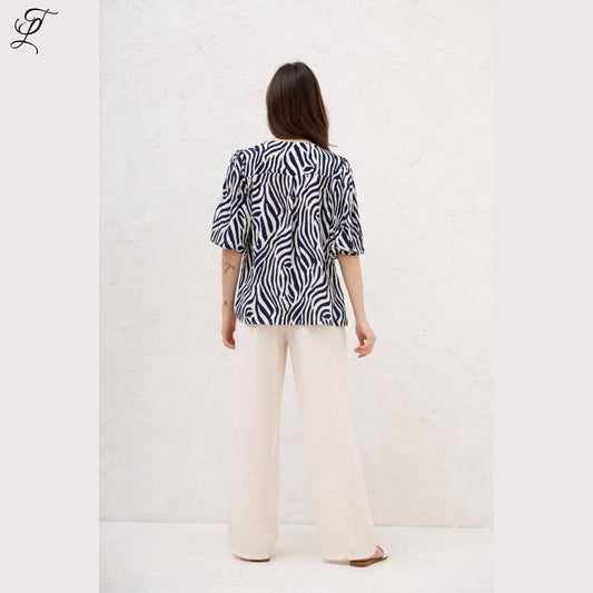 Achteraanzicht van vrouw die Chastar Viscose Blouse Zebra Print draagt met elegante pofmouwen en losse fit.