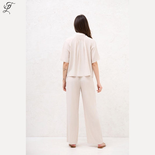 Achteraanzicht van een vrouw die de luchtige Chastar Korte Mouwen Blouse in beige draagt met een relaxte pasvorm.
