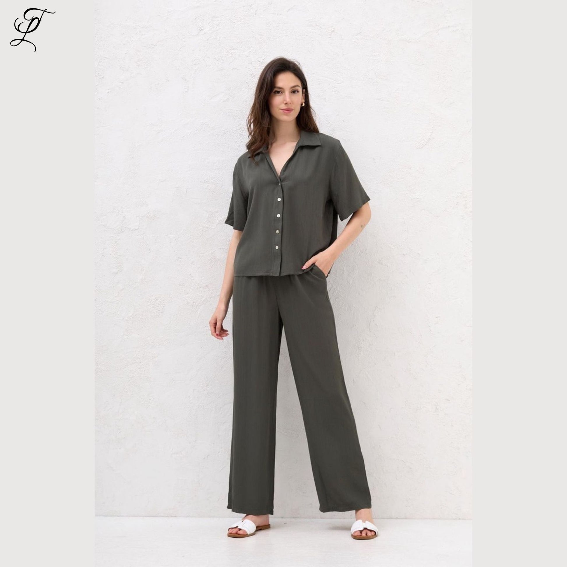 Vrouw draagt stijlvolle Chastar Korte Mouwen Blouse in army groen met parelmoerknopen, perfect voor casual en zomerse dagen.