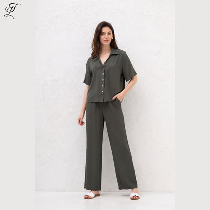 Vrouw draagt stijlvolle Chastar Korte Mouwen Blouse in army groen met parelmoerknopen, perfect voor casual en zomerse dagen.