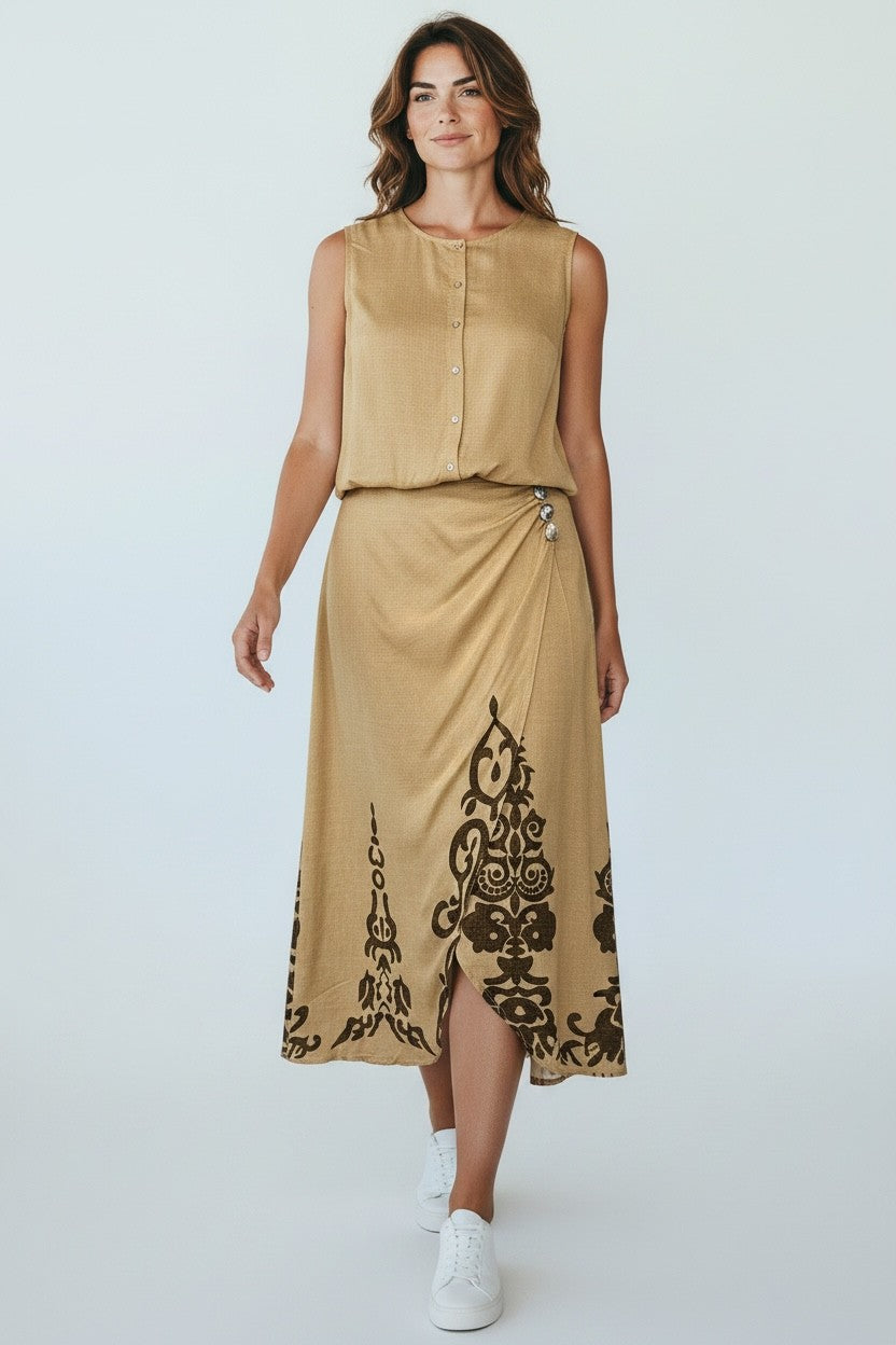 Model draagt beige mouwloze top met knoopsluiting en bijpassende lange rok met donkere print en knopen, onderdeel van de Chastar Nieuw Sets collectie.