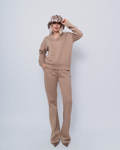 Dames Sweater V-hals Chastar Camel getoond in casual stijl met bijpassende broek en luipaardprint hoed. De sweater heeft een zachte camelkleurige tint en comfortabele pasvorm met v-hals detail. Perfect voor een complete look. | Home page, Truien, Collectie