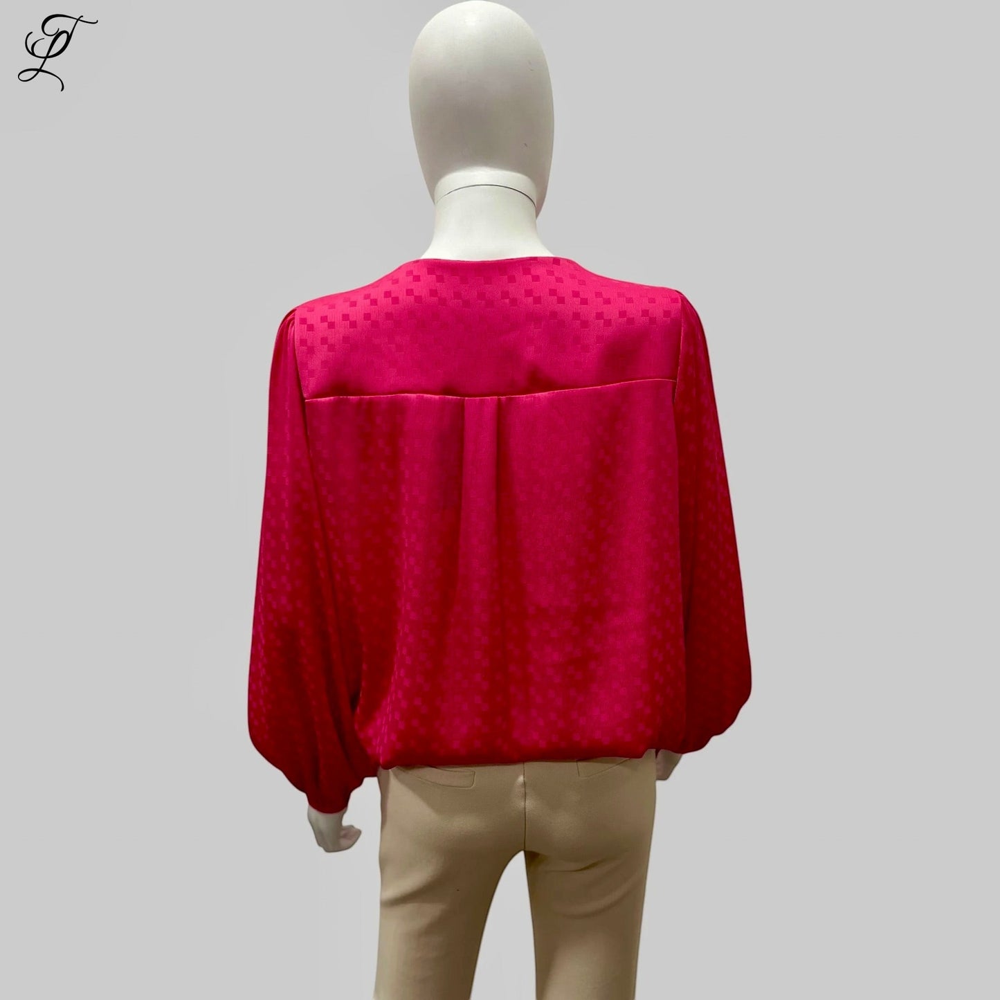 Chastar V-Hals Blouse in levendig fuchsia roze, gefotografeerd op een mannequin van achteren. De blouse toont een luchtige pasvorm met lange mouwen en elastische boorden, gemaakt van soepelvallende stof met subtiel ingeweven patroon. Collectie Blouses.