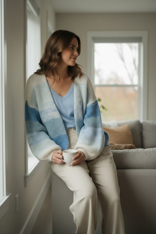 Vrouw draagt gebreide vest met blauw-witte strepen uit de nieuwe collectie van Chastar in een comfortabele setting.