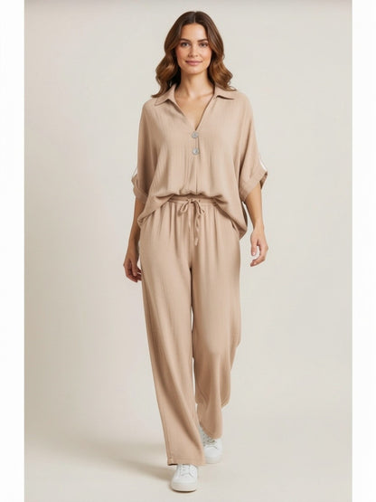 Model draagt losvallende beige set met korte mouwen en knoopsluiting, elastische tailleband, onderdeel van de Chastar Nieuw collectie Sets.