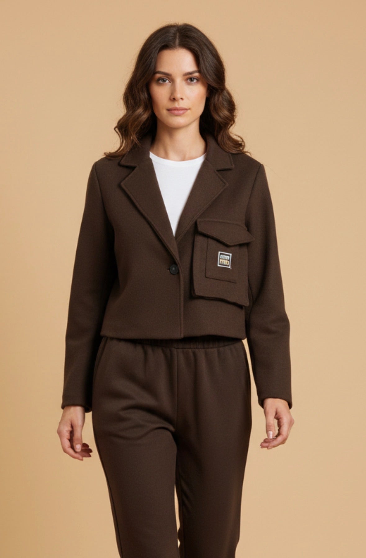 Chastar Blazer Elegant met Klepzak in bruin met reverskraag en korte pasvorm, gedragen door een model.