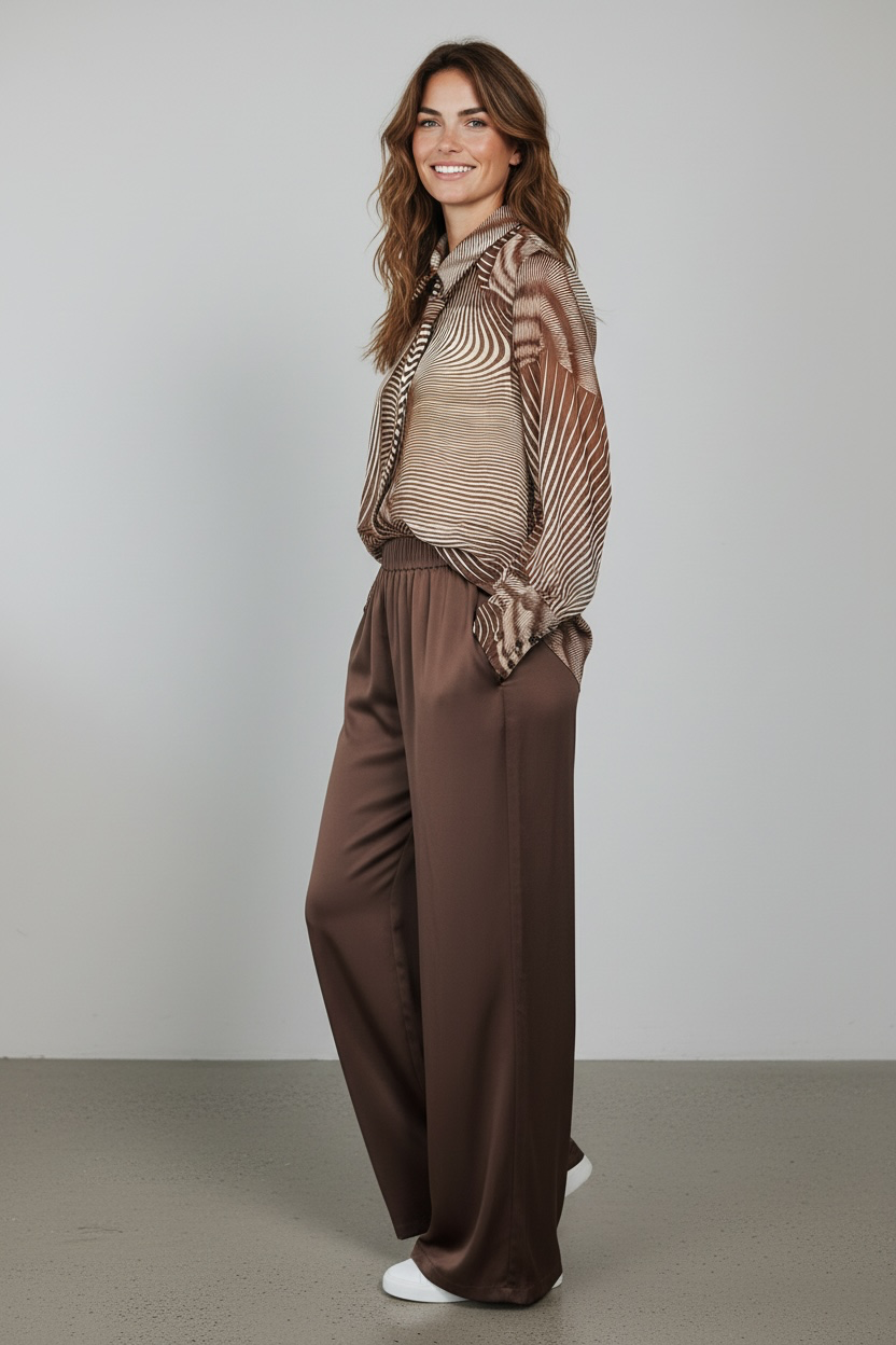Chastar Blouse Noémie in Bruin op een model, zijaanzicht met golvend lijnendessin en brede manchetten