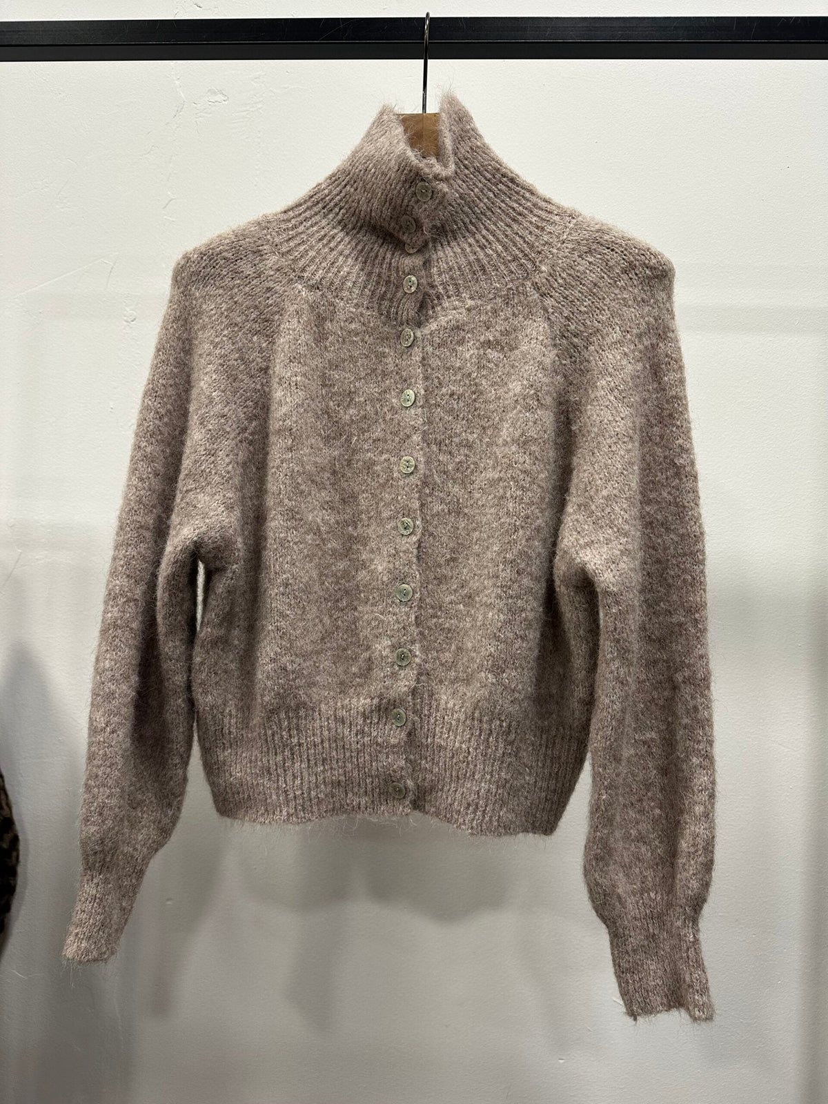 Chastar Cardigan Gebreid met hoge kraag in taupe met knoopsluiting en geribde boorden, aan een kledinghanger.