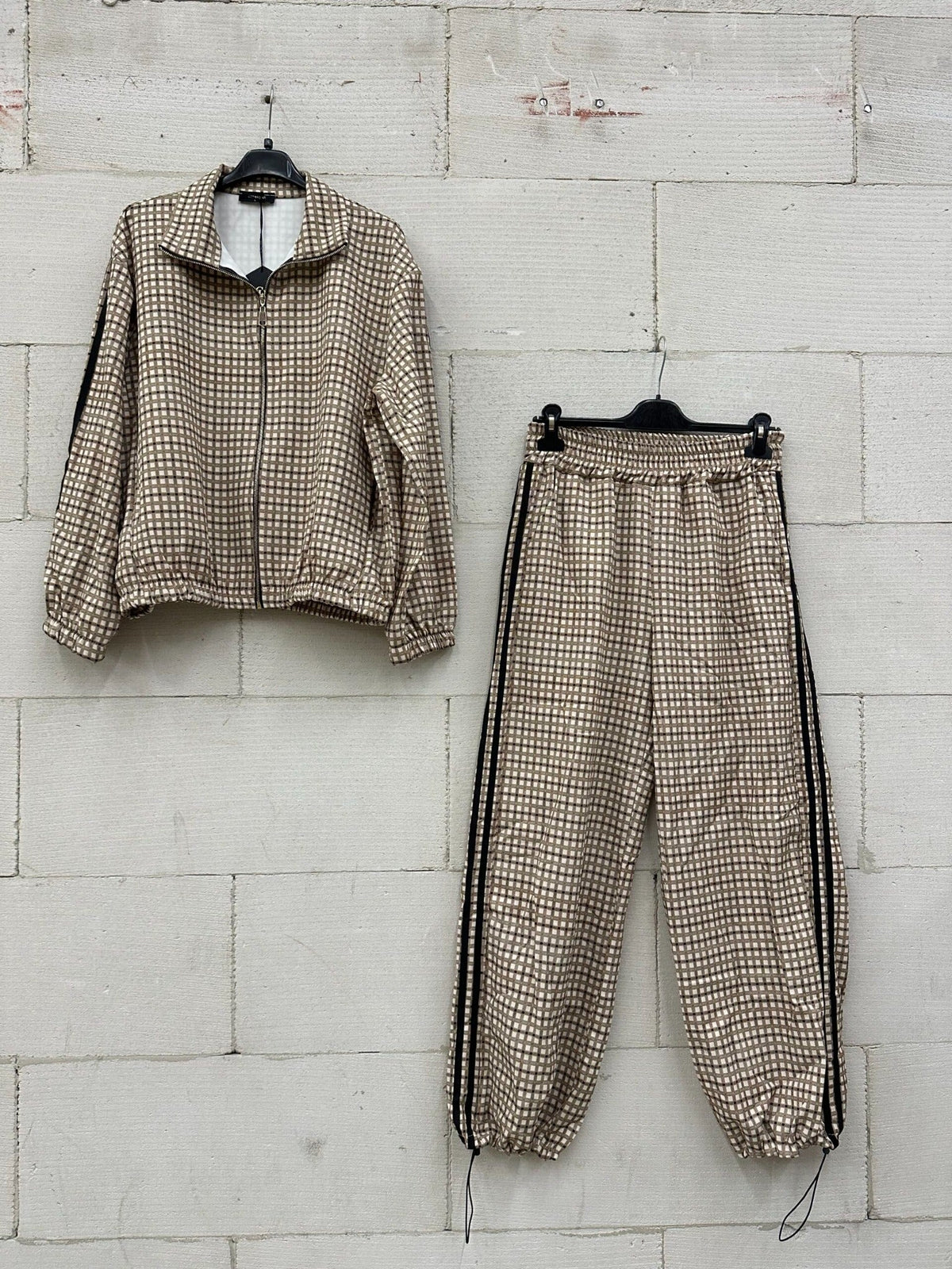 Chastar Set Vivienne in bruin met ruitpatroon, ritsjasje en bijpassende broek aan kledinghangers