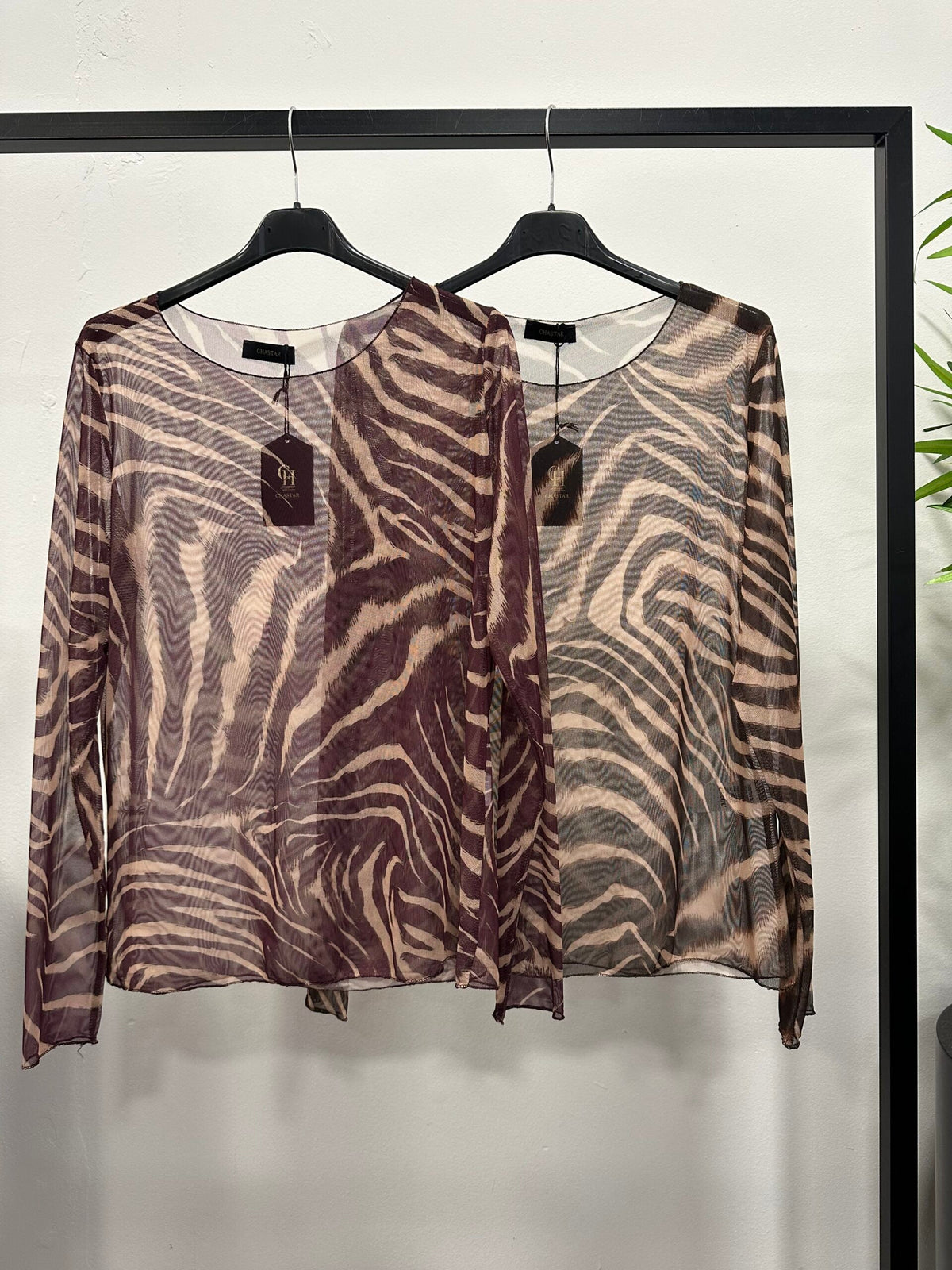 Chastar Top Noura in bordeaux en bruin met transparante mesh, zebraprint en lange mouwen, aan kledinghangers.