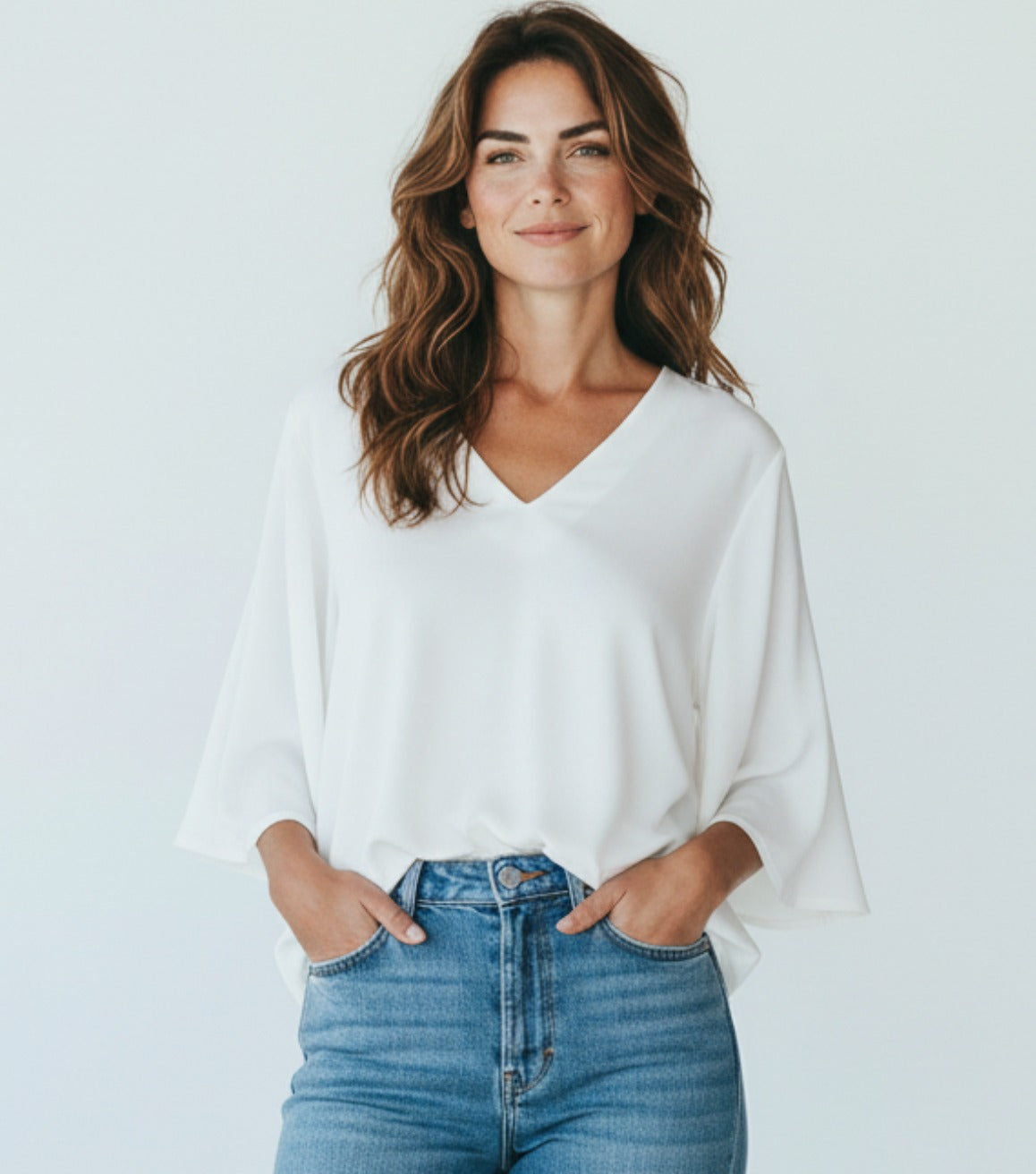 Offwhite top van zijde en viscose met V-hals en wijde mouwen, gedragen door een model met jeans.