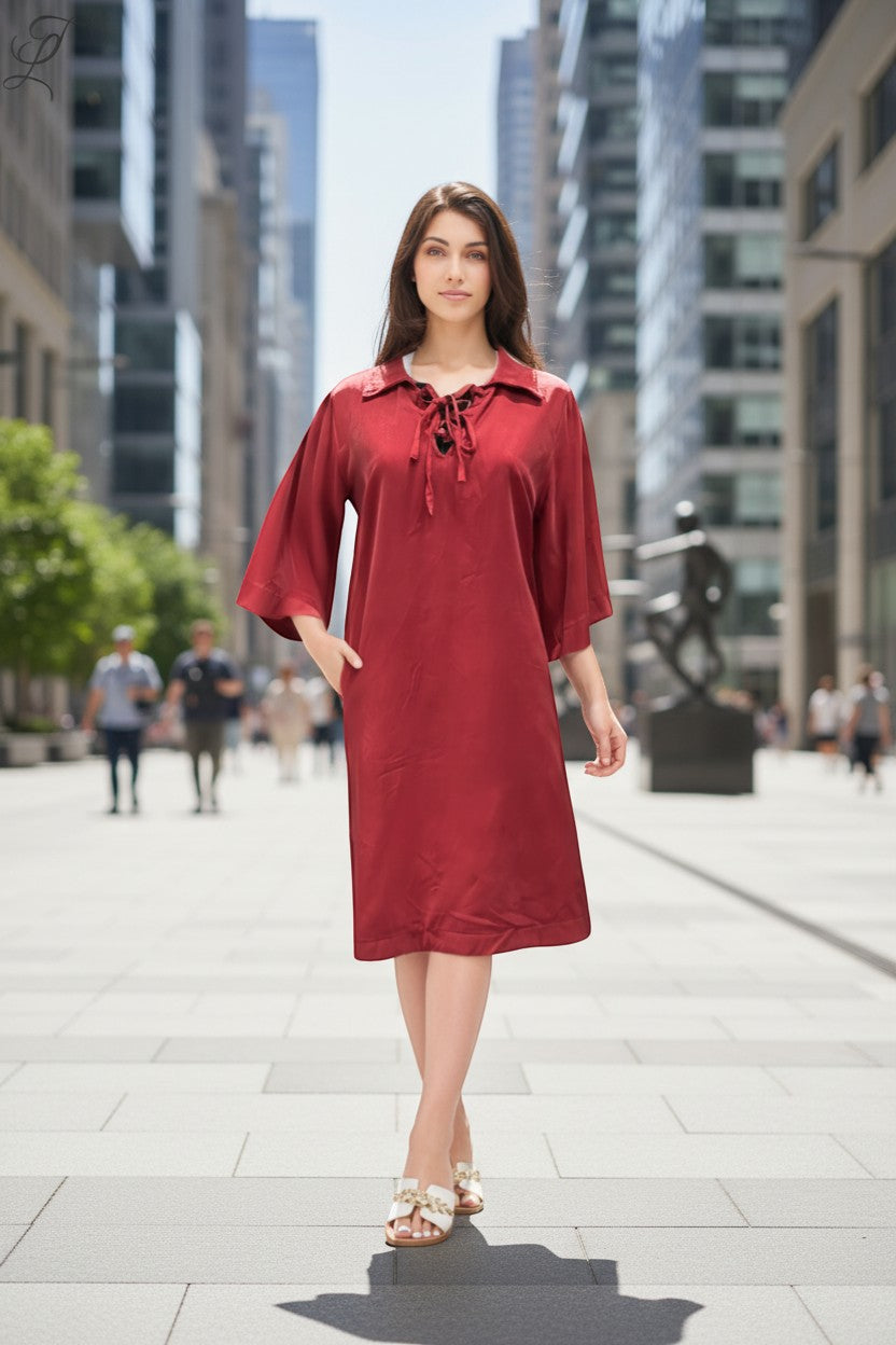 Trendy Leslie Chastar Lyocell dress in deep red with a collar and lace-up detail, featuring wide sleeves and pockets.