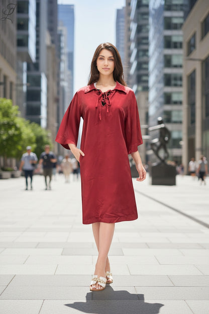 Trendy Leslie Chastar Lyocell dress in deep red with a collar and lace-up detail, featuring wide sleeves and pockets.