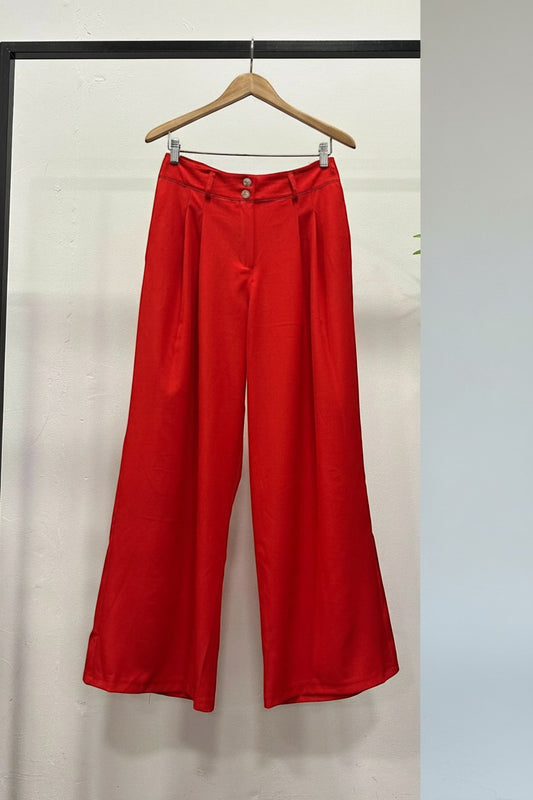 Trendy Leslie red satin wide-leg pleated high-waisted trousers with a relaxed fit and subtle sheen.
